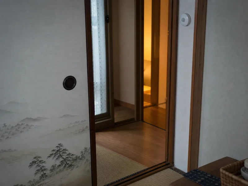 実家の玄関ドアに取り付けられた小さな開閉センサーの写真